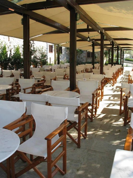 a row of white covered chairs and tables