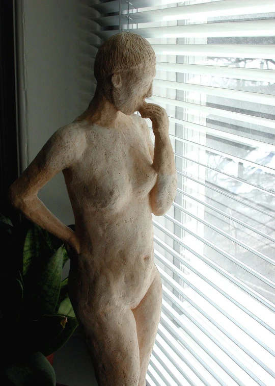 a very statue is standing in front of a window