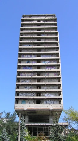 a building with graffiti on the side and a parking lot below