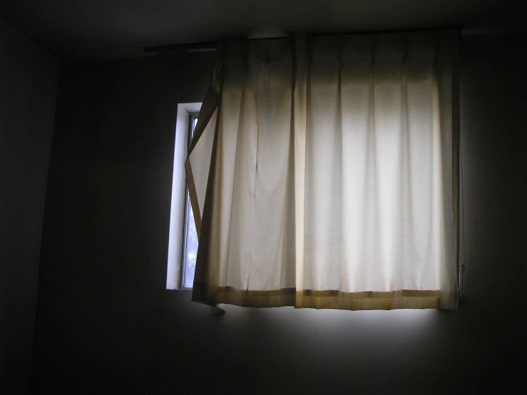 the light from the blinds onto the window shines on a dimly lit room