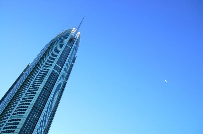 the tall building has a jetliner flying in the sky