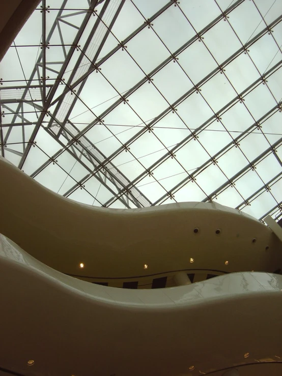 a sculpture sitting in front of an empty glass ceiling