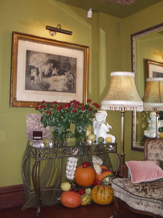 an antique desk with roses and pumpkins sitting on it