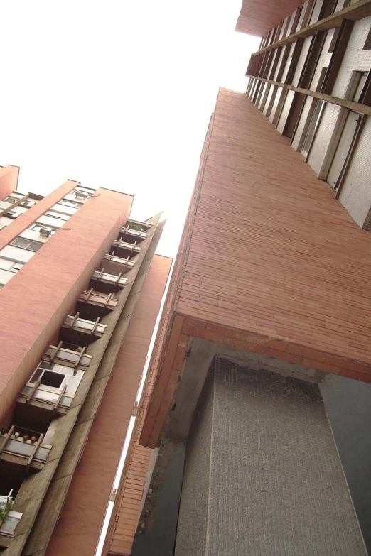 the side of buildings with balconies, and a skateboarder is outside