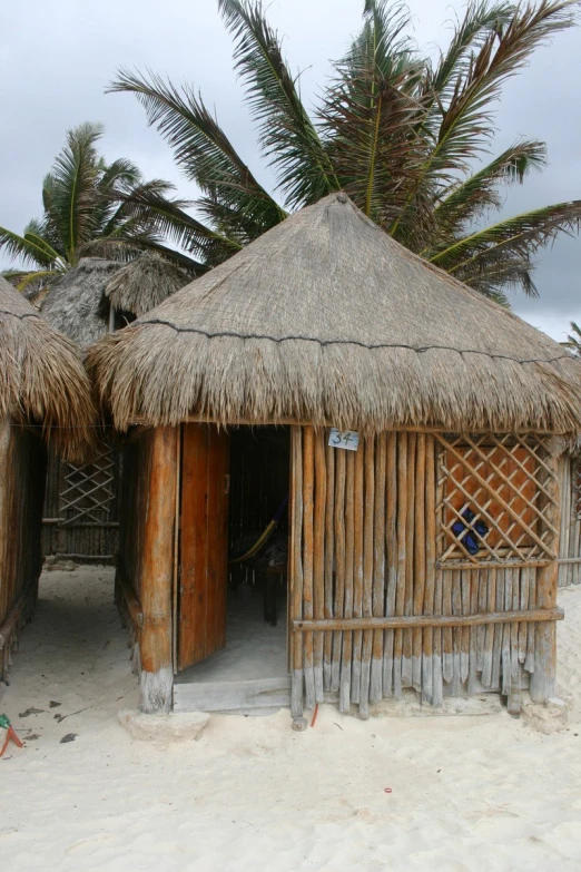 several wooden huts sitting on top of a sandy beach