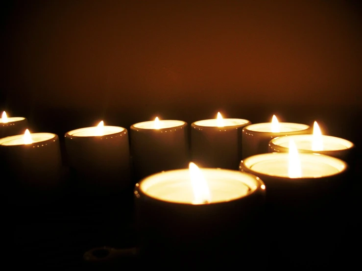 a bunch of candles that are lit in the dark