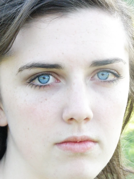 a close up s of a woman with long hair and blue eyes