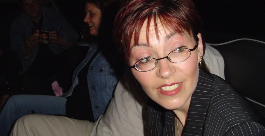 woman wearing glasses and a striped shirt with red hair