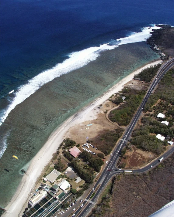 an aerial view of a long road next to the ocean