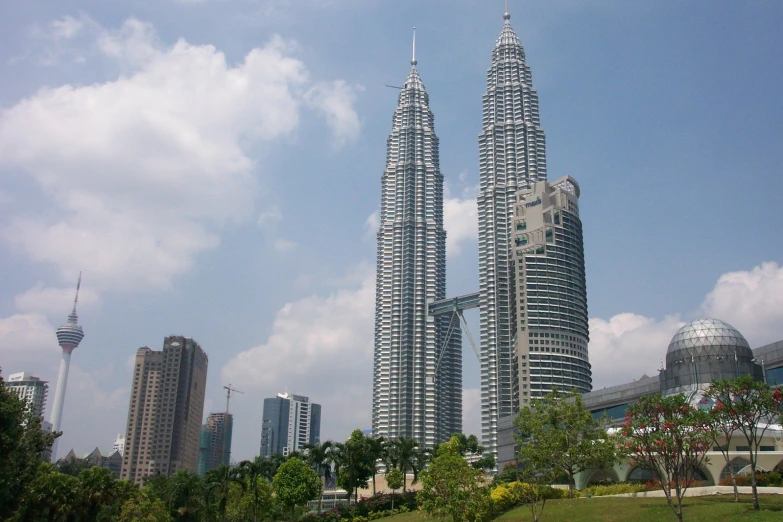 tall skyscrs are against a blue sky with clouds