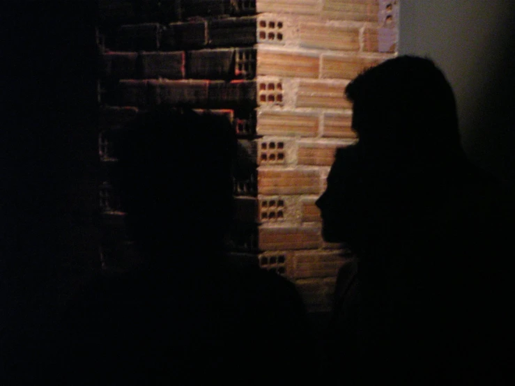 a group of people standing next to a brick wall