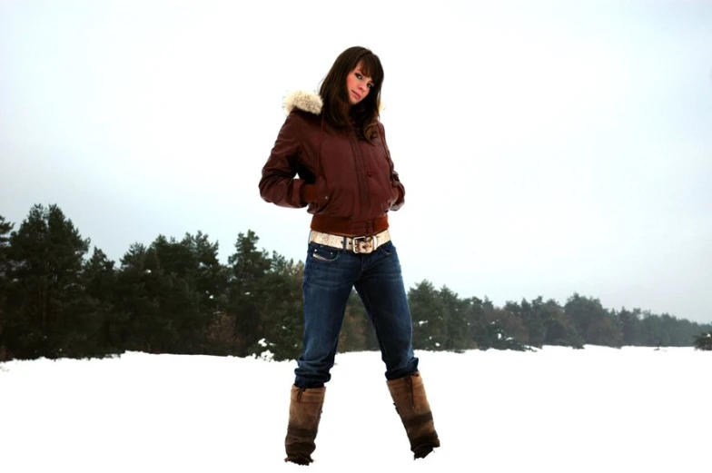 a woman is standing in the snow wearing boots