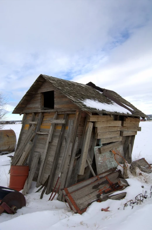 an old building in the middle of the snowy field