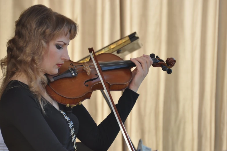 a young lady playing a violin with strings