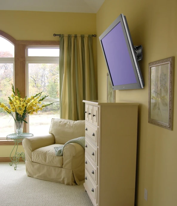 a television mounted on the wall above a chair