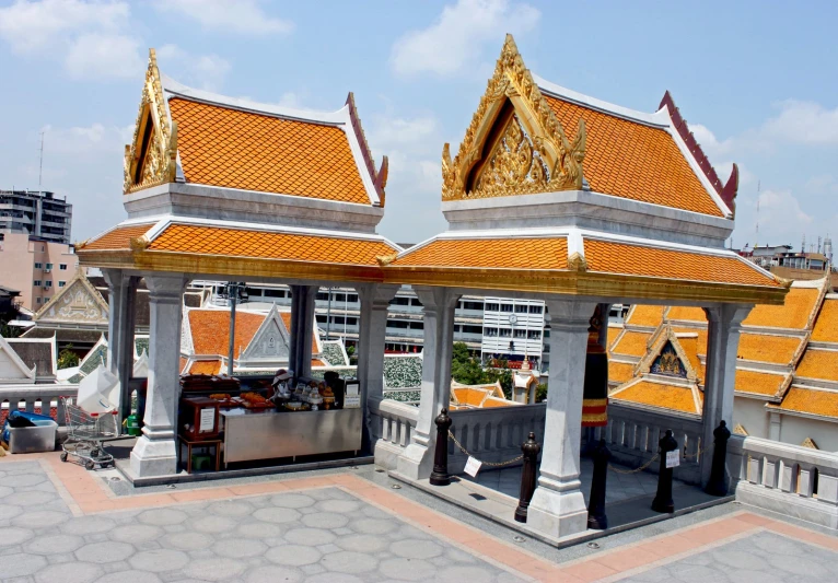 the roof of a building with some gold leafy tiles