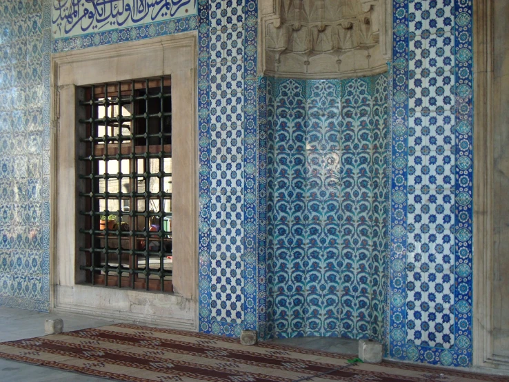 a decorative tile wall with a window in the middle