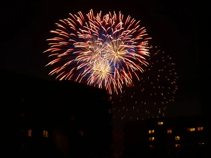 fireworks exploding on the night sky in a town