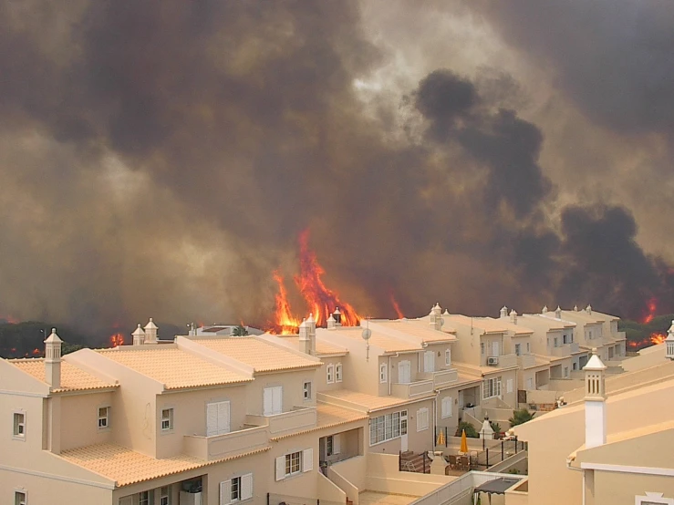 smoke rises above the city of houses during a fire