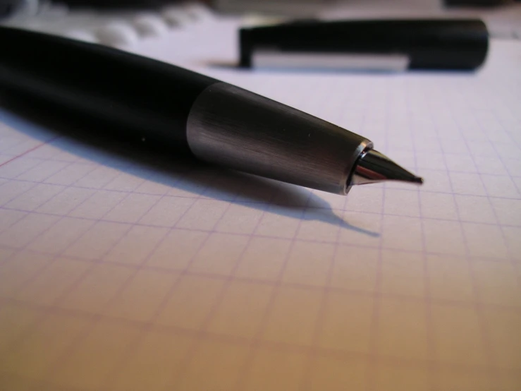 a pen sits on top of a graph paper