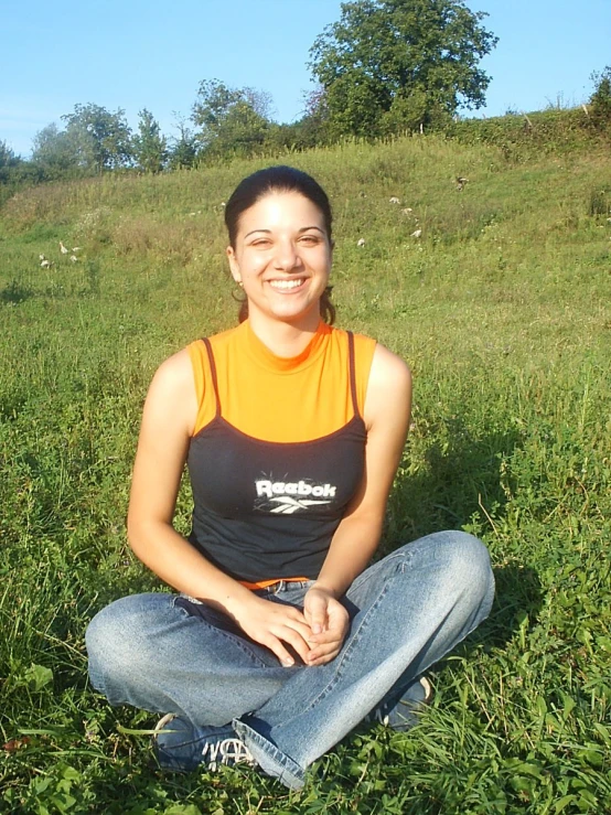 woman sitting in the grass outside, smiling