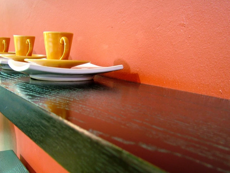 some yellow cups are lined up on a table