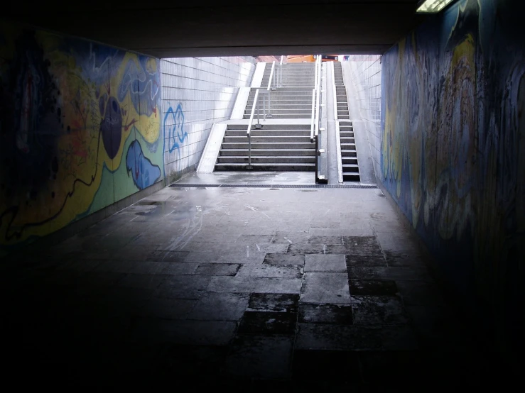 a dark hallway with graffiti on the walls