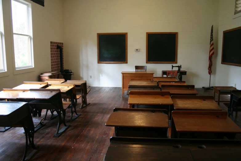 a room with a row of desks and some chalkboard