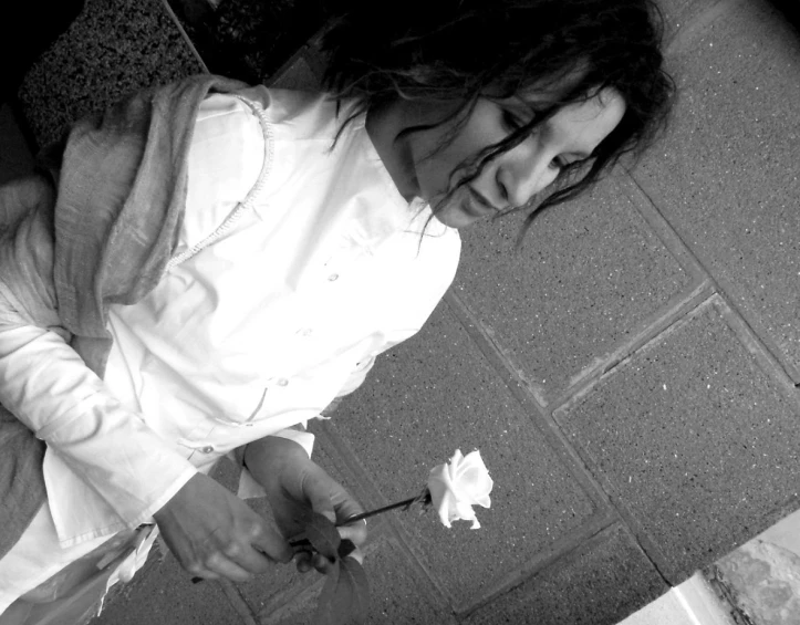 a black and white po of a woman holding a flower