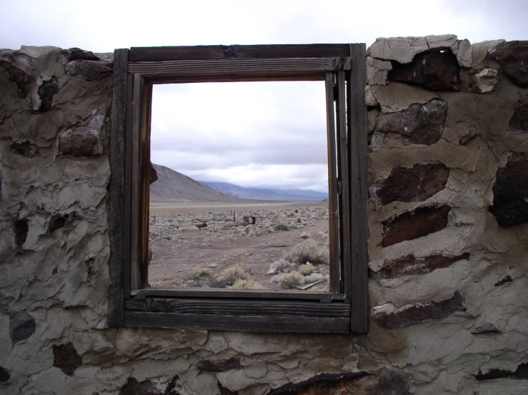 a window that is looking in to a stone wall