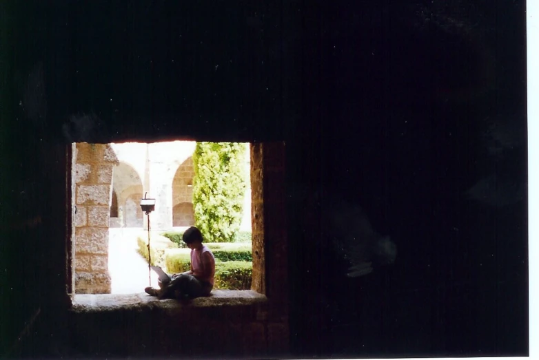 a girl sitting in an open window in an old church