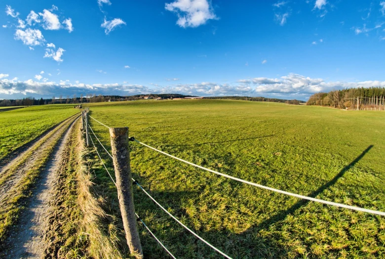 a large field with a lone truck on it