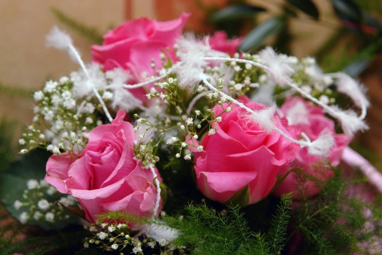 a bouquet with pink roses is displayed on the table