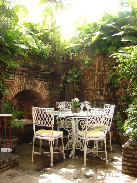 a small patio area with white chairs and tables