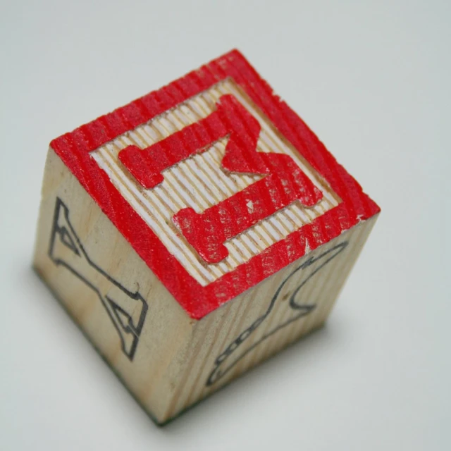 an odd red wooden block with a hand written arrow