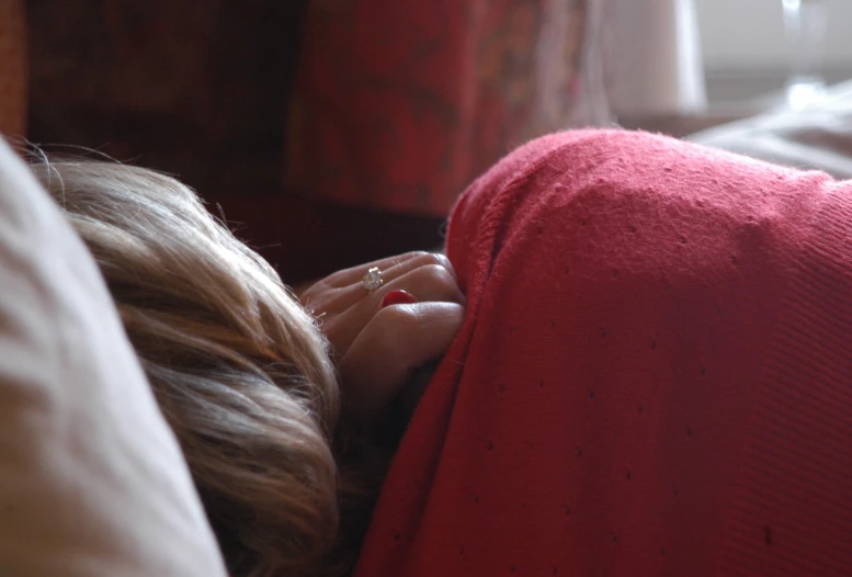 a close up of a person sitting on a bed