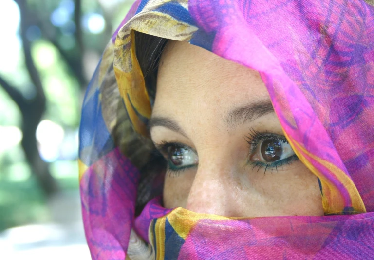 a close up of a person wearing a pink scarf