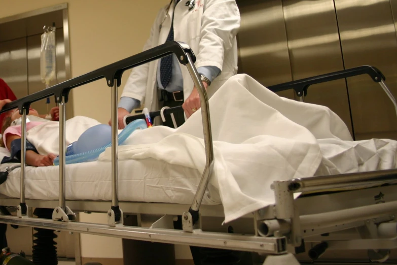 two doctors are doing a medical procedure in an empty bed