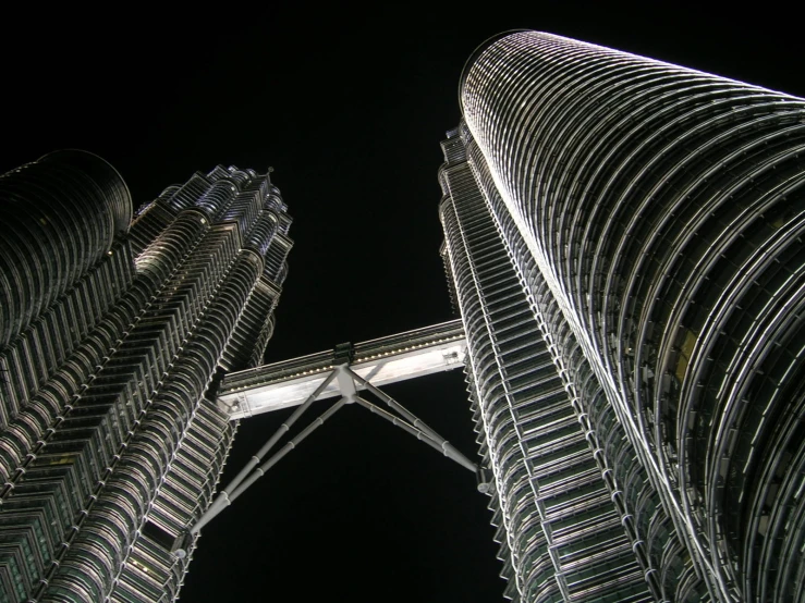 two tall skyscrs on the top side of one another at night