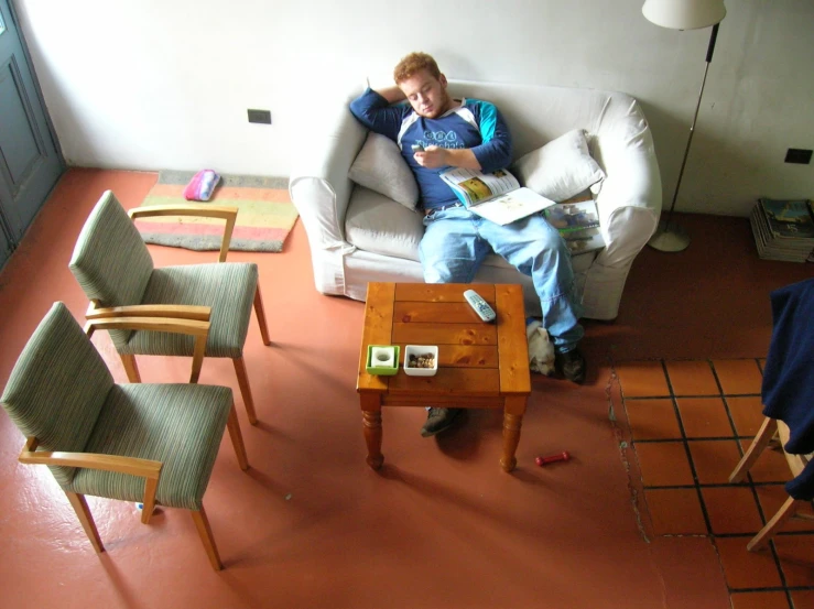 a man reading a book on top of a couch