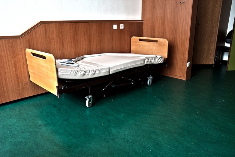 a bed in an empty hospital with one door open