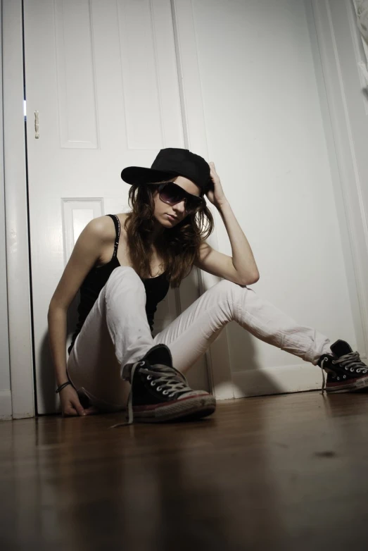 girl with black hat and black shirt sitting on the ground