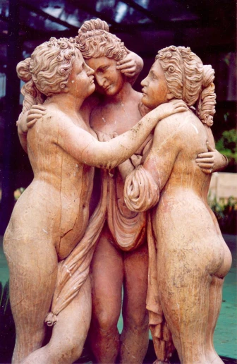 a small statue of a woman hugging two other women