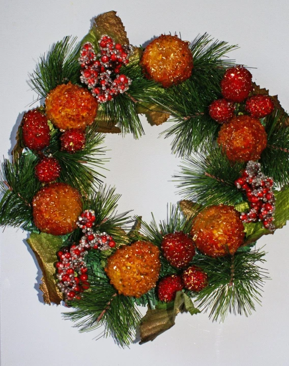 an oval christmas wreath with berries and pine sprigs