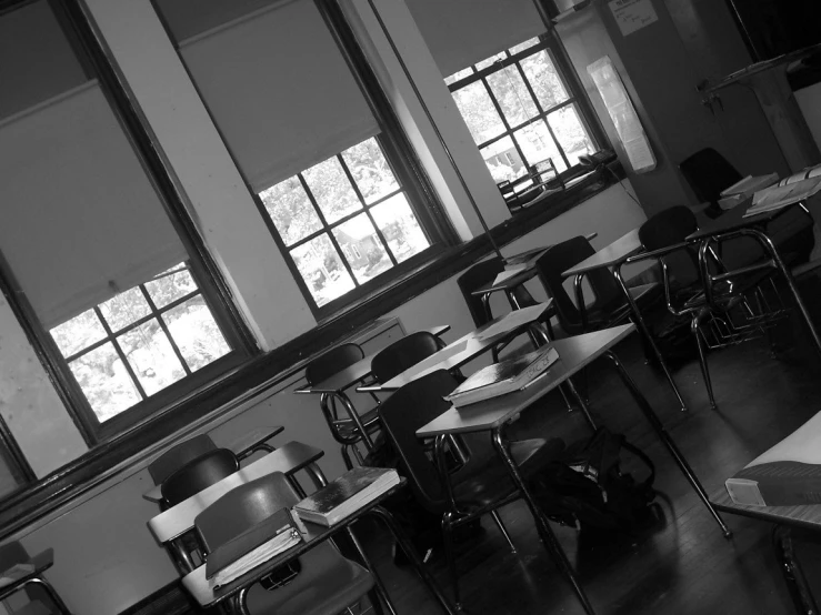 several empty desks in a classroom with lots of windows