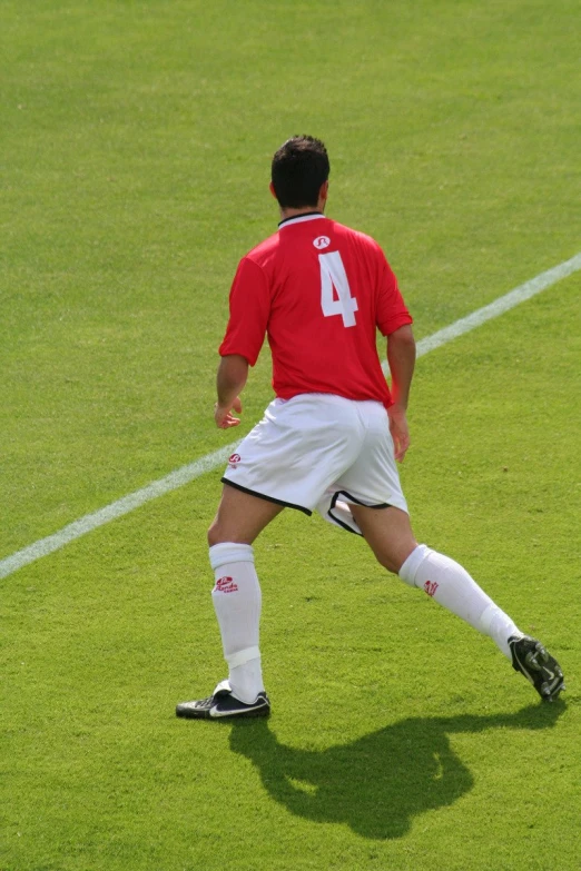 a soccer player on the field with ball in mid air