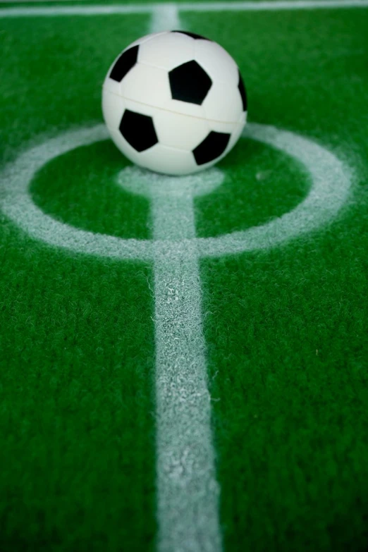 a soccer ball in the middle of a green soccer field