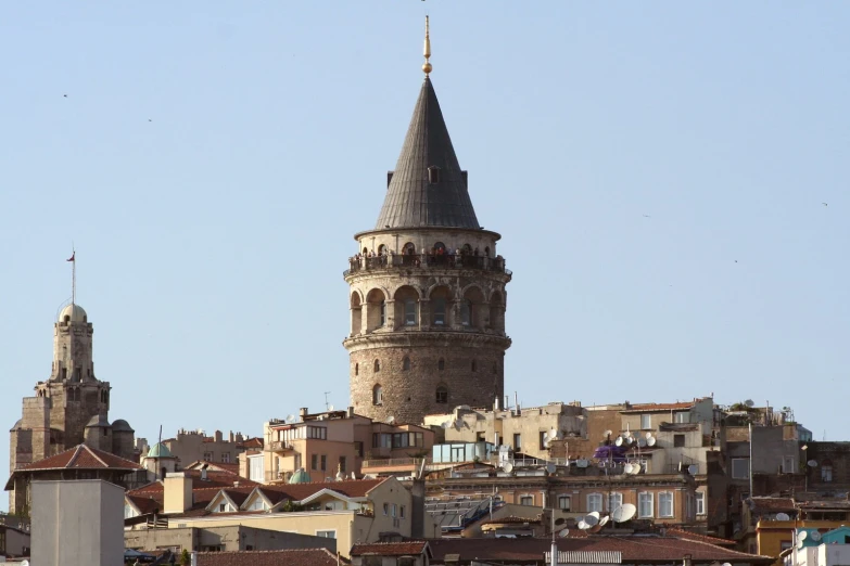 a tall tower next to a city with buildings