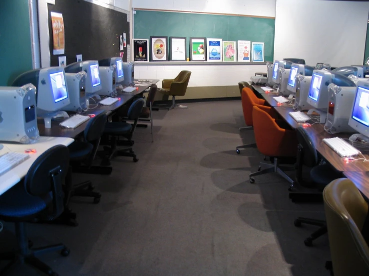 a row of computer monitors and keyboard in a room