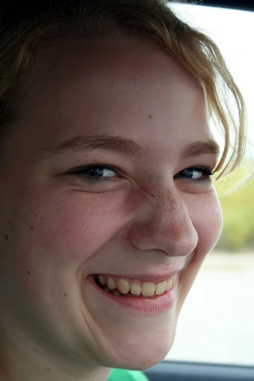 a woman smiling in the back of a car